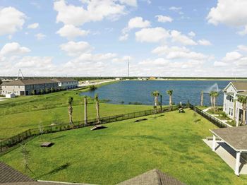 A house is situated on a grassy area with a body of water in the background.